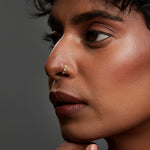 Side profile of a woman wearing the gemstone gold nose ring with natural makeup