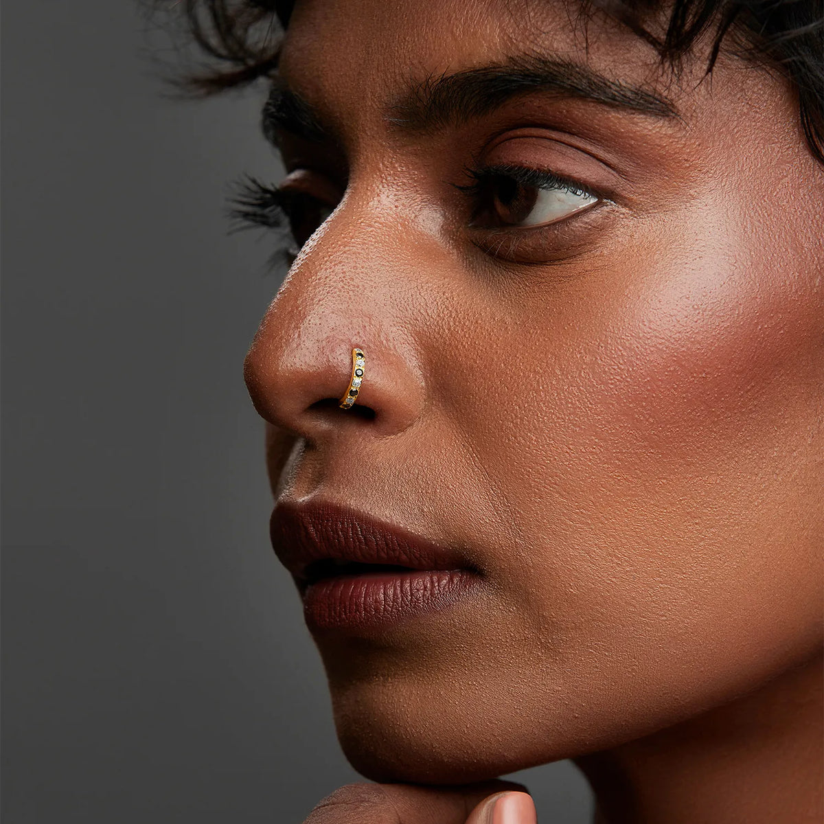 Side profile of a woman wearing the gemstone gold nose ring with natural makeup