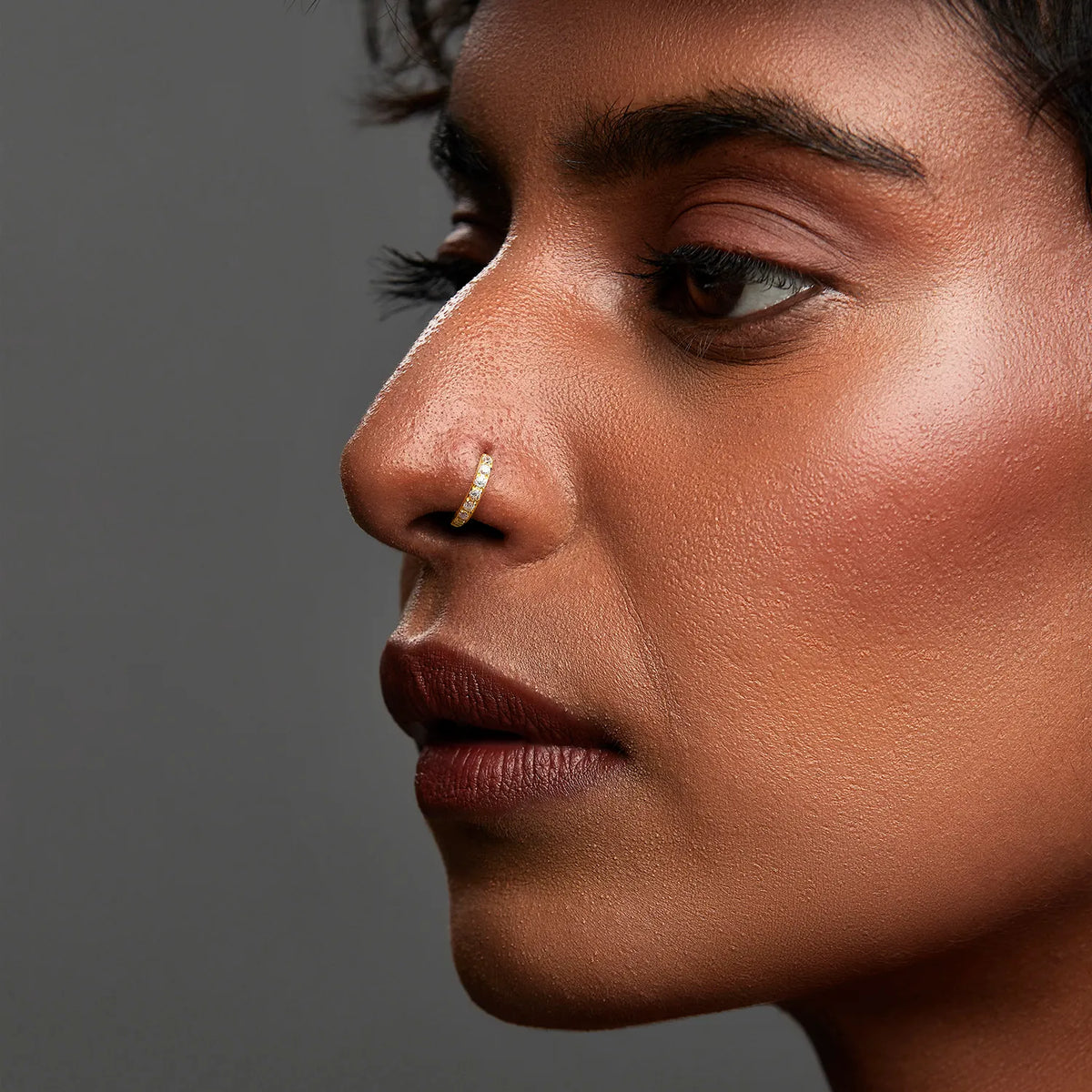 Close up side angle of a woman wearing the gemstone gold nose ring highlighting facial harmony