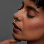 Woman wearing a leaf design gold nose ring shown in a close up profile highlighting elegant styling