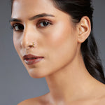 Side profile of a woman wearing a minimalist 18K gold hoop nose ring showcasing an elegant everyday look