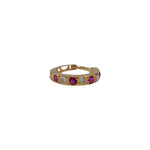 Front view of gemstone set gold nose ring on a white background displaying circular design