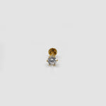 Front view of white stone gold nose pin placed upright on neutral surface