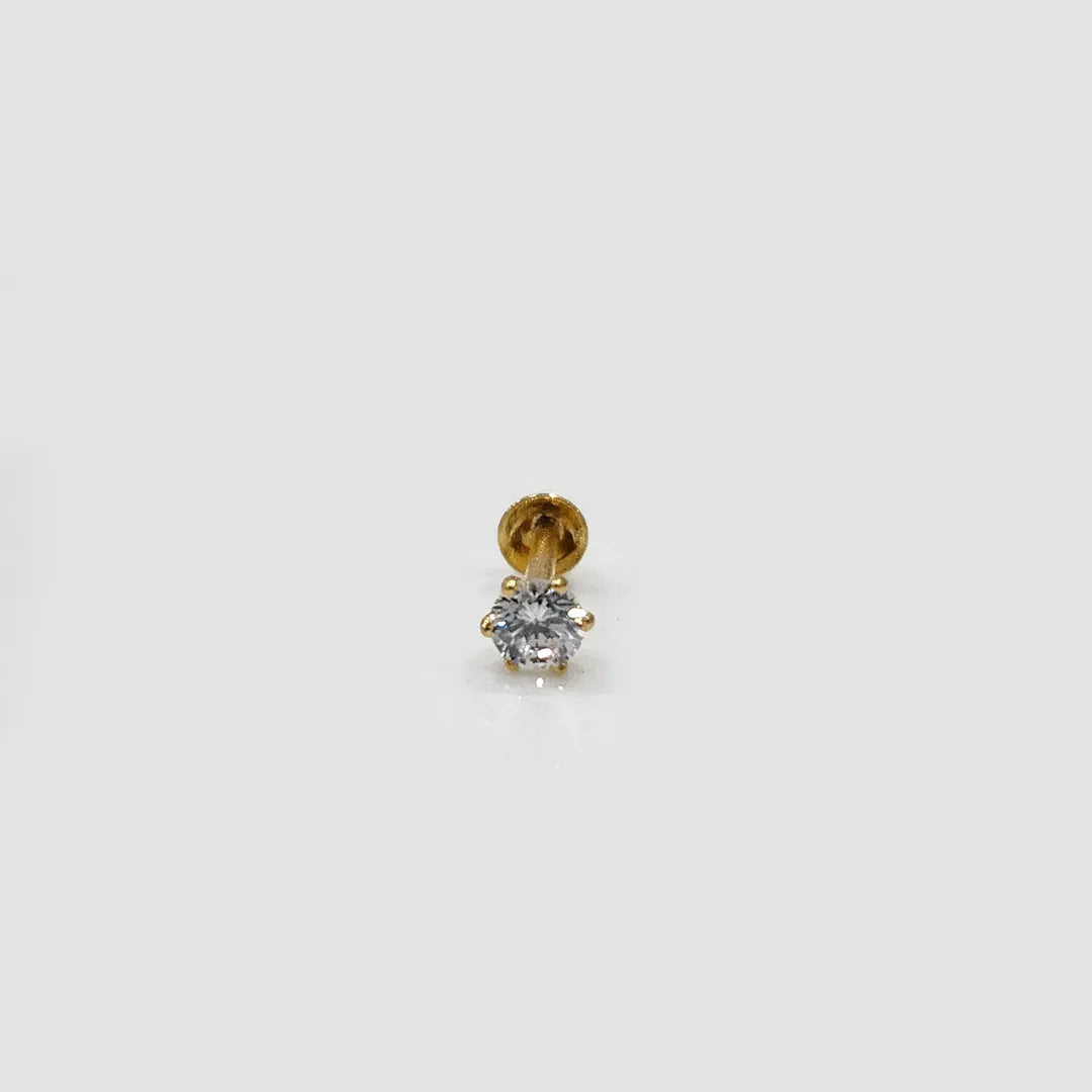 Front view of white stone gold nose pin placed upright on neutral surface