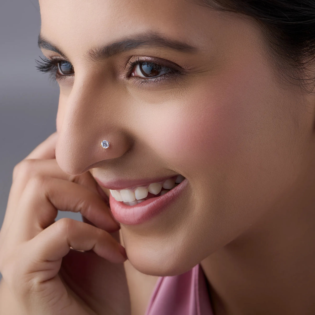 Woman smiling while wearing a white stone gold nose pin demonstrating everyday elegance