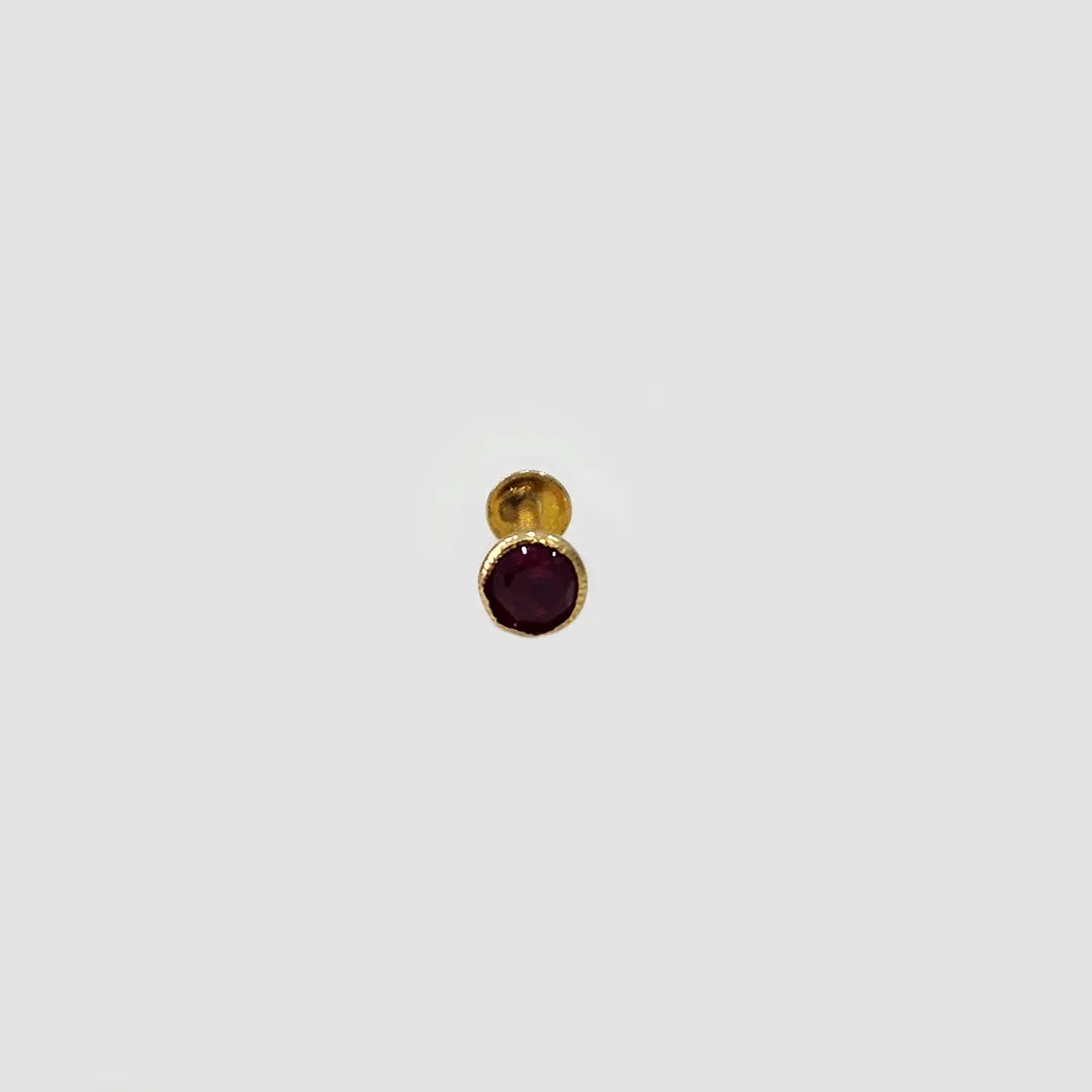 Gold stone nose pin with black gemstone front view on white background