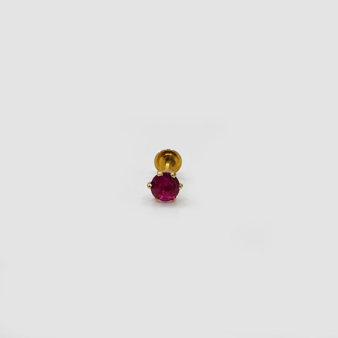Close up of ruby stone gold nose pin on neutral background