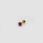Gold stone nose pin with red gemstone on a white background