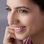 Woman wearing ruby stone gold nose pin smiling softly