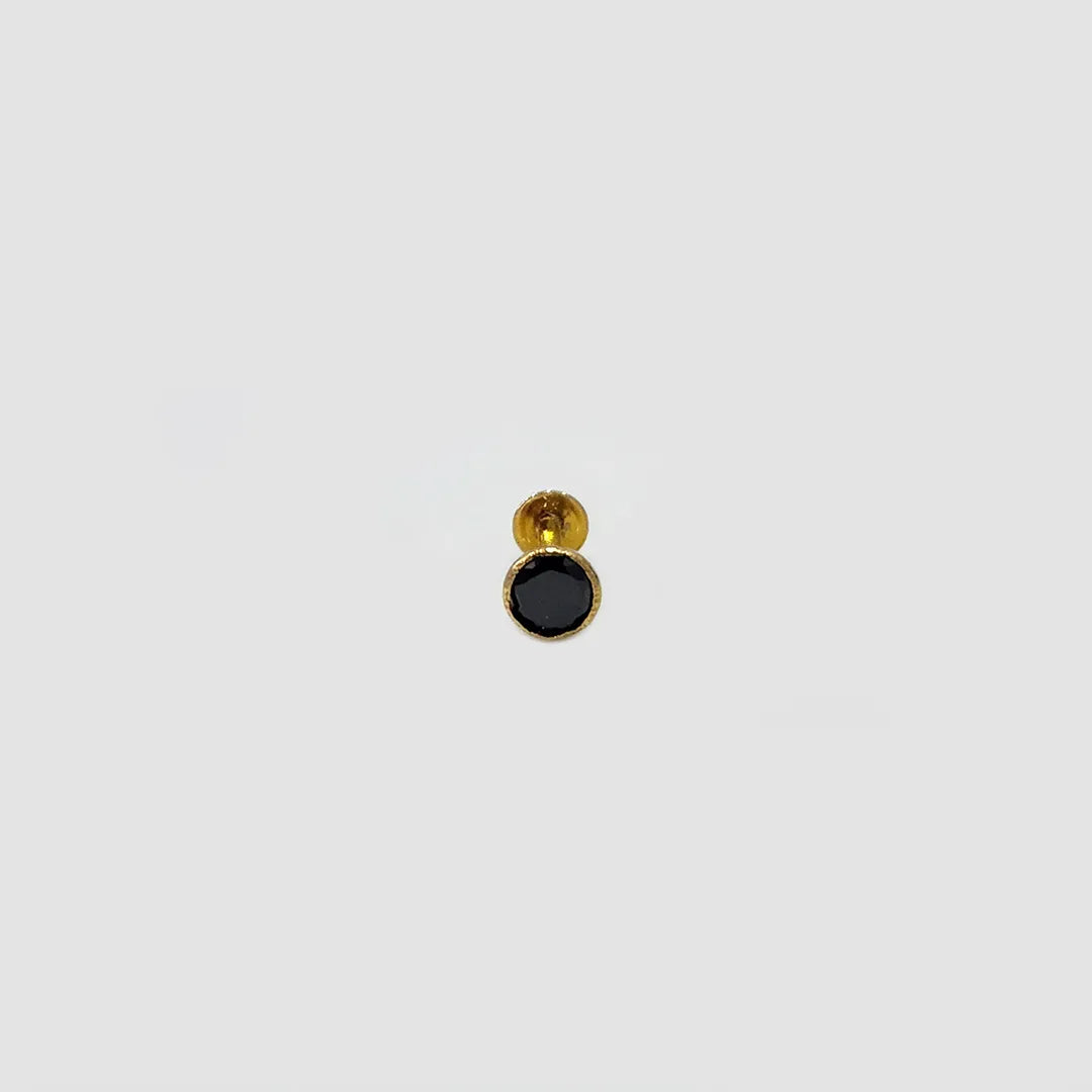 Minimal gold nose pin with black gemstone isolated on white background