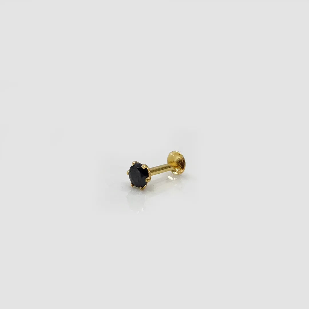 Close up of blue stone gold nose pin placed on light surface