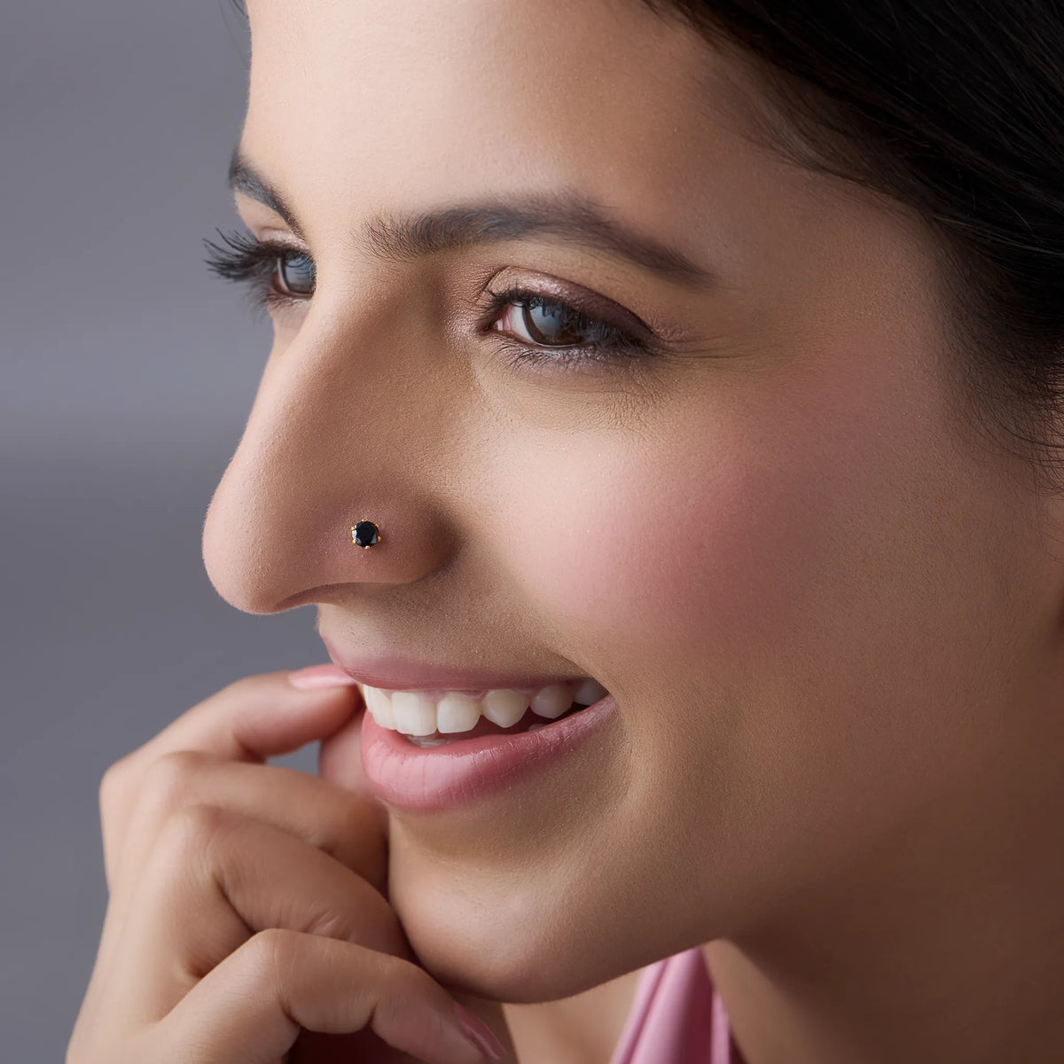 Woman wearing black stone gold nose pin styled for modern look