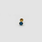 Gold stone nose pin with blue gemstone on a light background