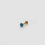 Gold stone nose pin with blue gemstone angled side view on white background