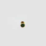 Gold stud nose pin with round green gemstone on a light gray background