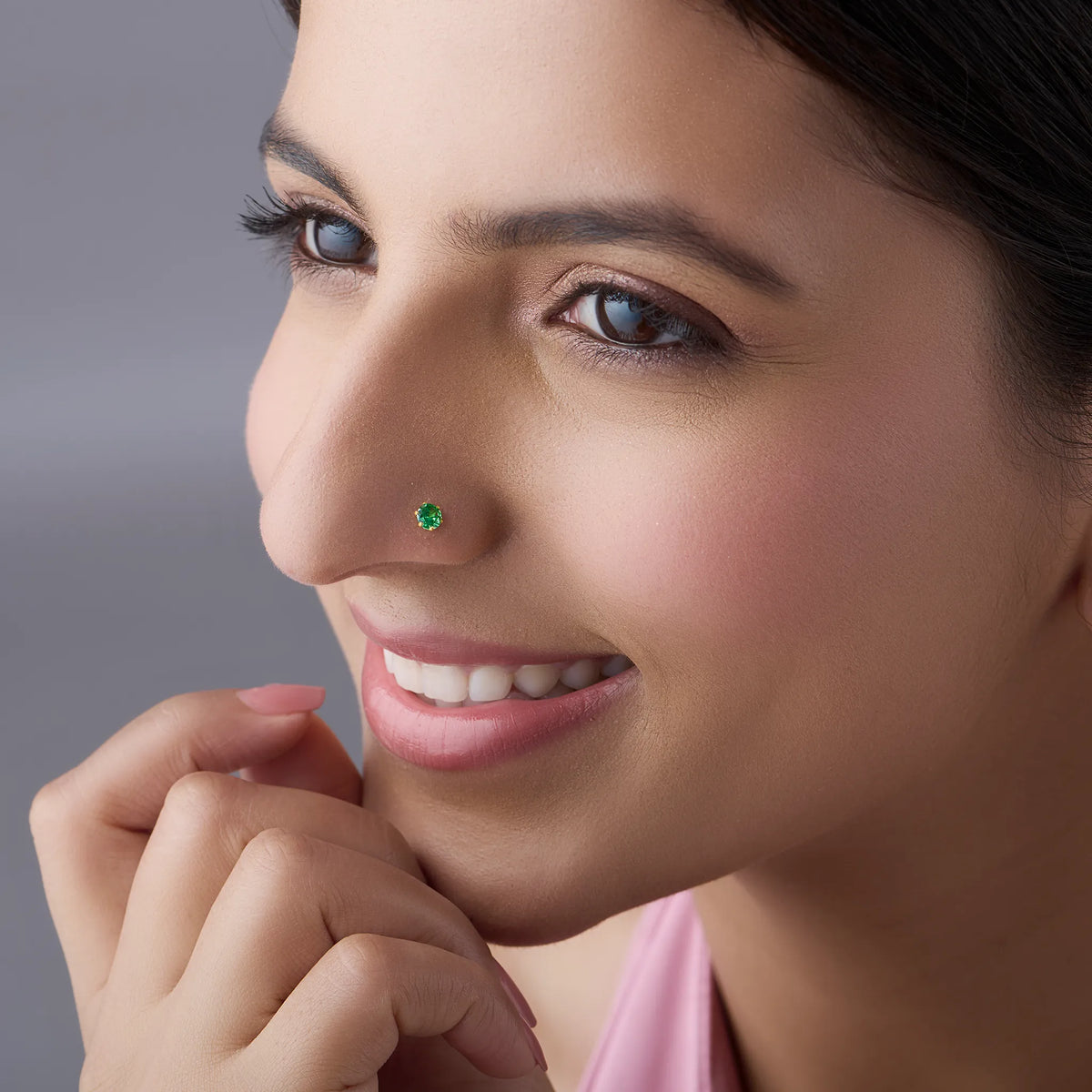 Woman wearing green stone gold nose pin smiling naturally