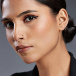 Woman wearing a minimal gold nose ring shown in a close up portrait for fit reference