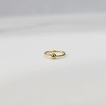 Close up of open hoop gold nose ring placed on a white background showing the clasp free open design