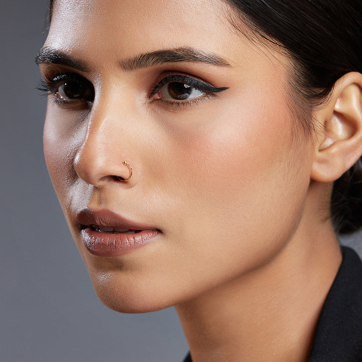 Woman wearing a simple ball accent gold nose ring showcasing elegant everyday styling on the face