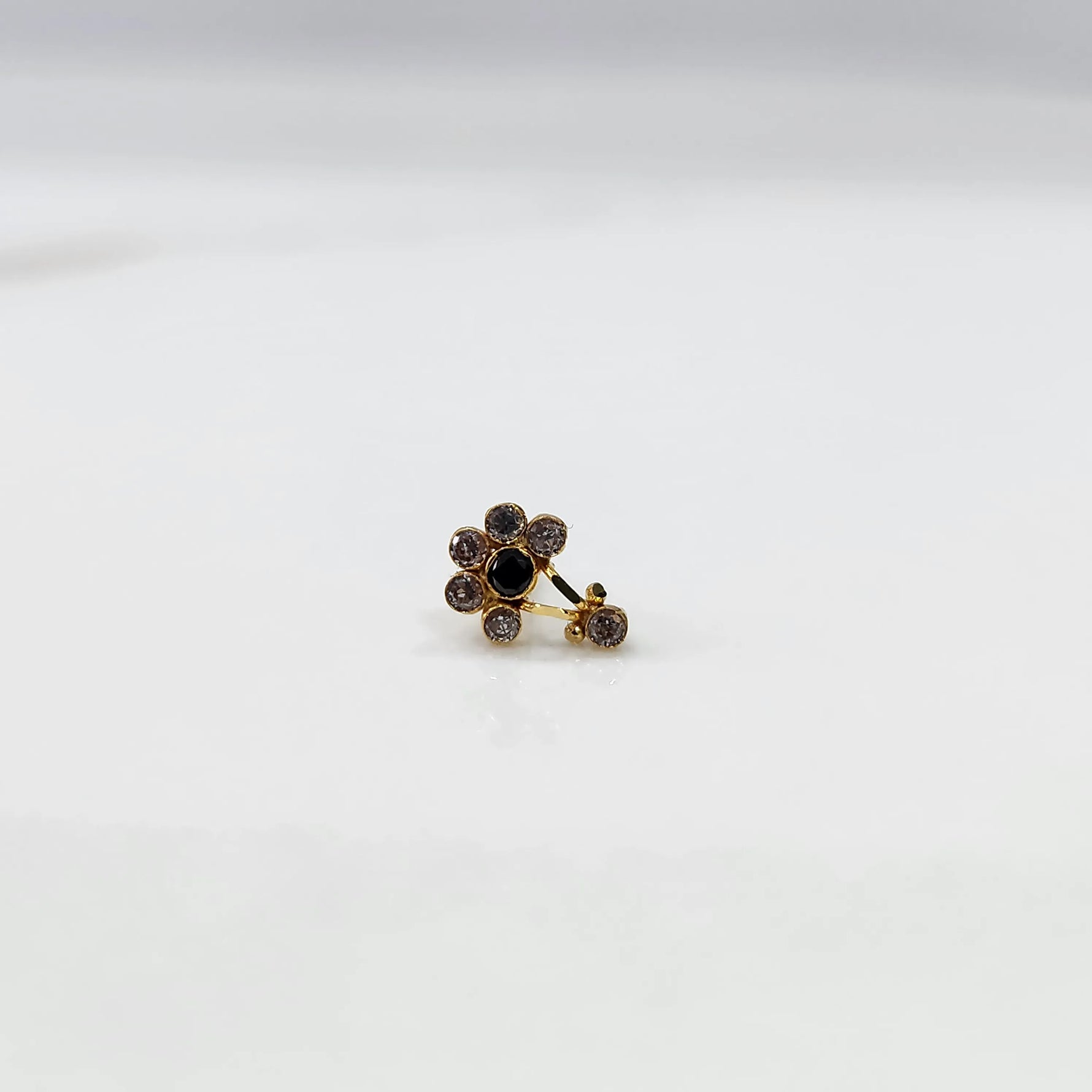 Antique-style gold ring with amethyst-toned stones, onyx center, plus hanging accent