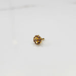 Top-down view of gold ring with purple gemstone petals