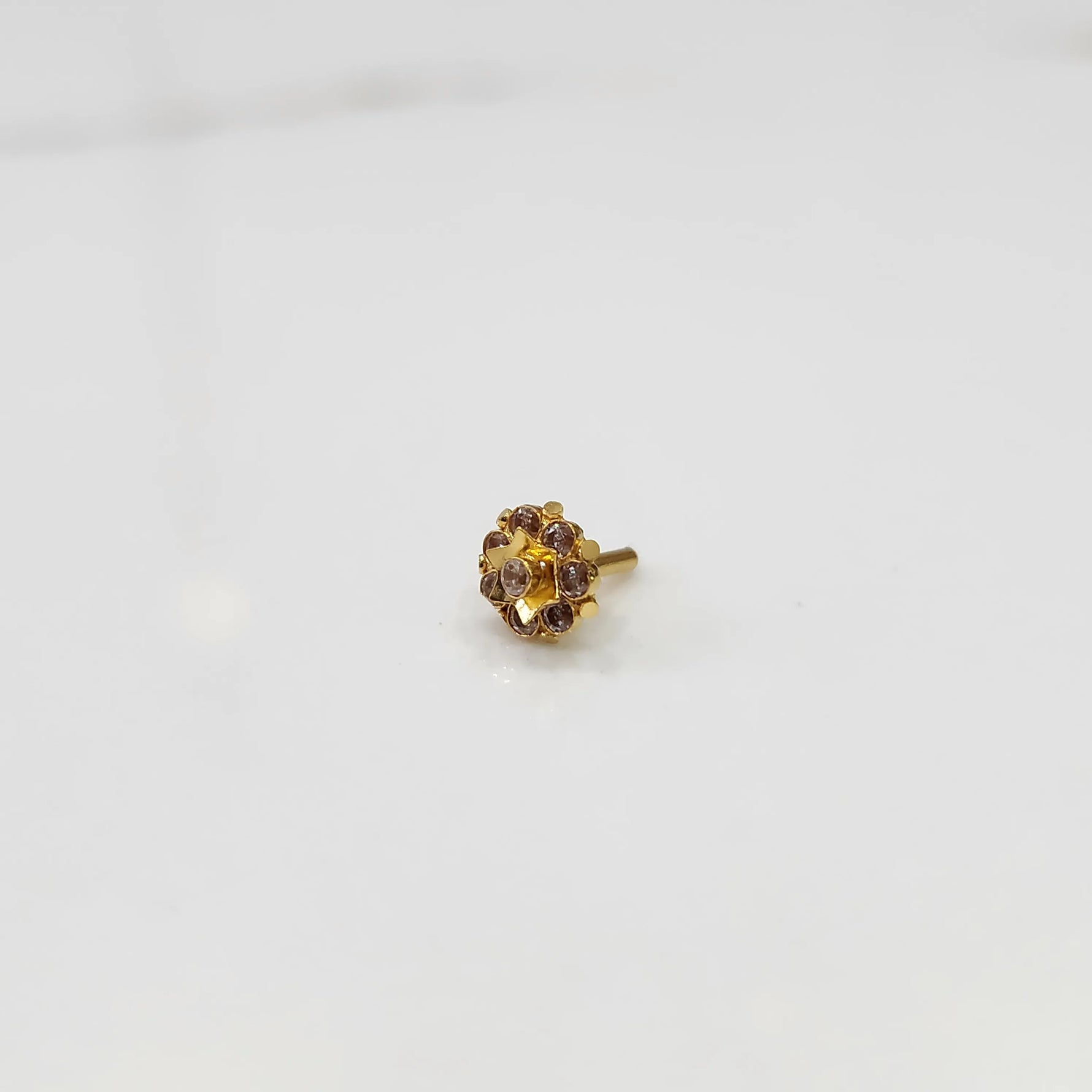 Top-down view of gold ring with purple gemstone petals