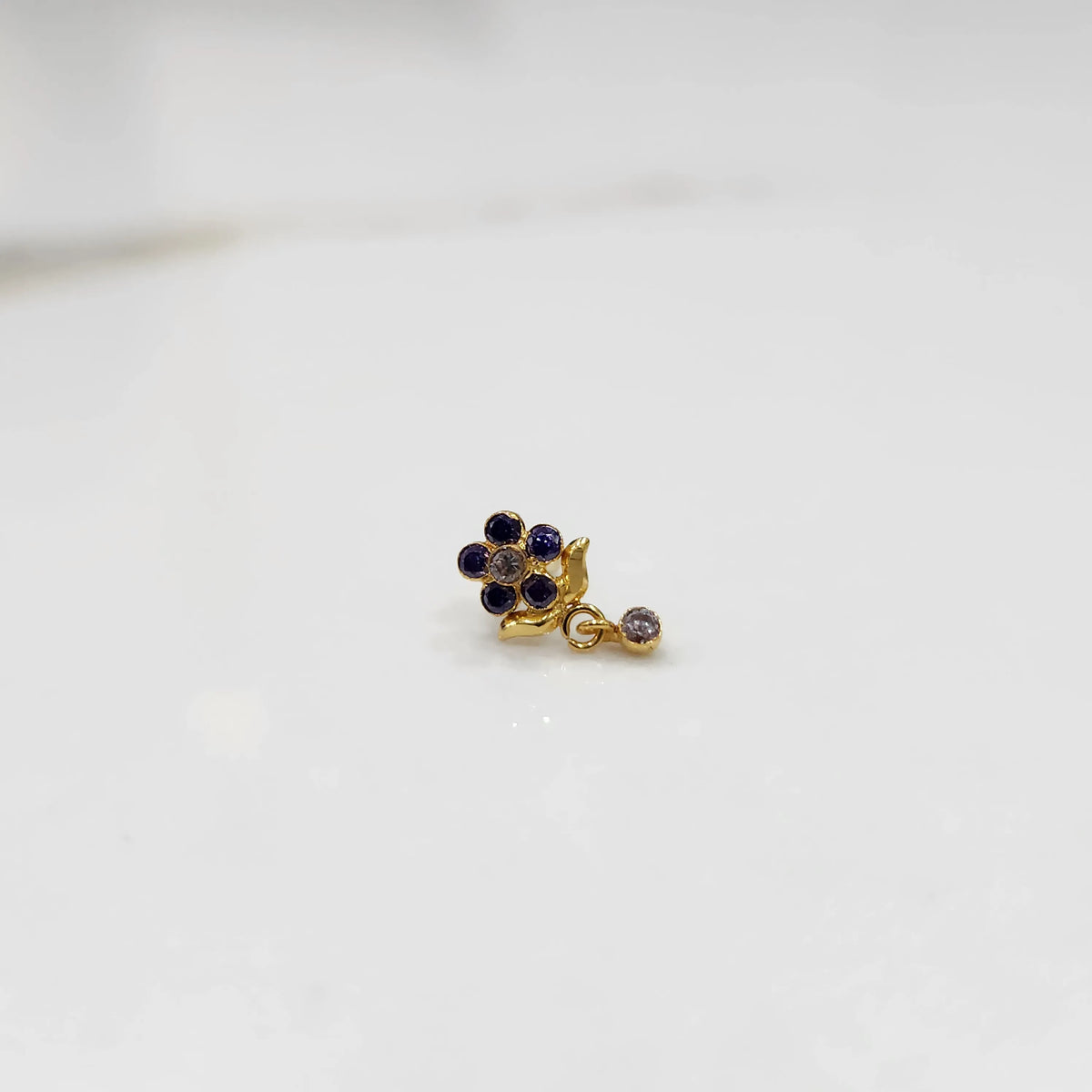Gold ring with blue sapphire floral dangle design, side view