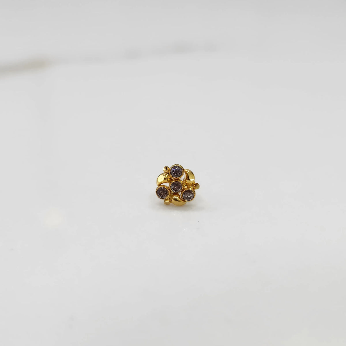 Side view of gold ring featuring brown gemstone cluster in round floral pattern