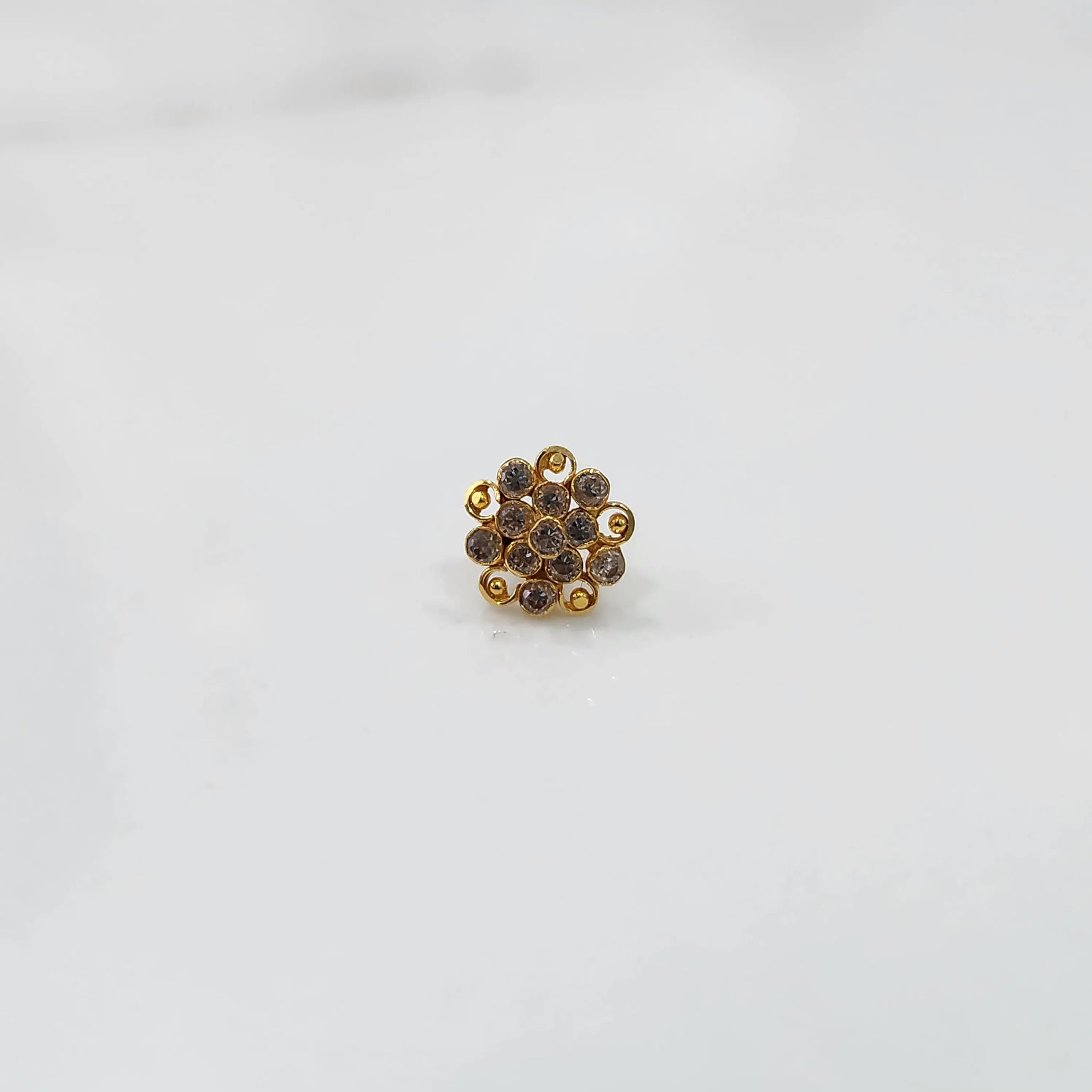 Front view of gold ring with layered clear gemstone petals