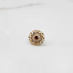 Antique-style gold ring featuring clear-toned stones with a ruby center