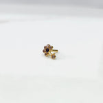 Front view of gold ring featuring clear floral gemstones with blue center and drop pendant