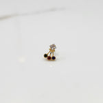 Antique-style gold ring featuring a square stone and hanging colored gems