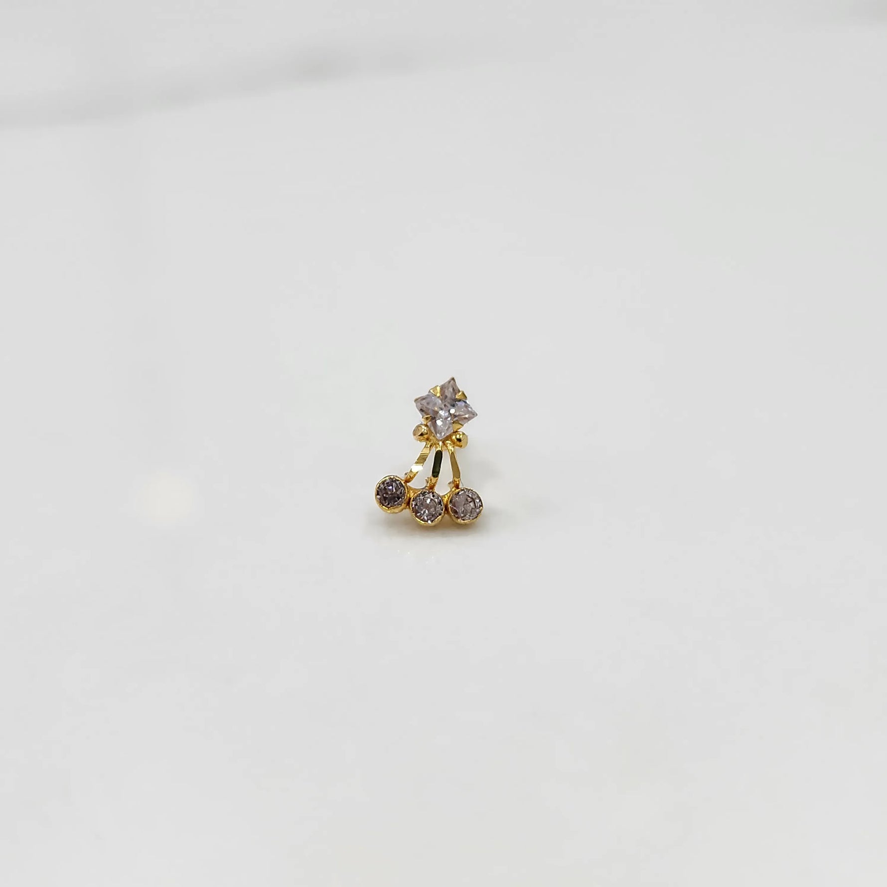 Antique-style gold ring featuring a square stone and hanging brown gems