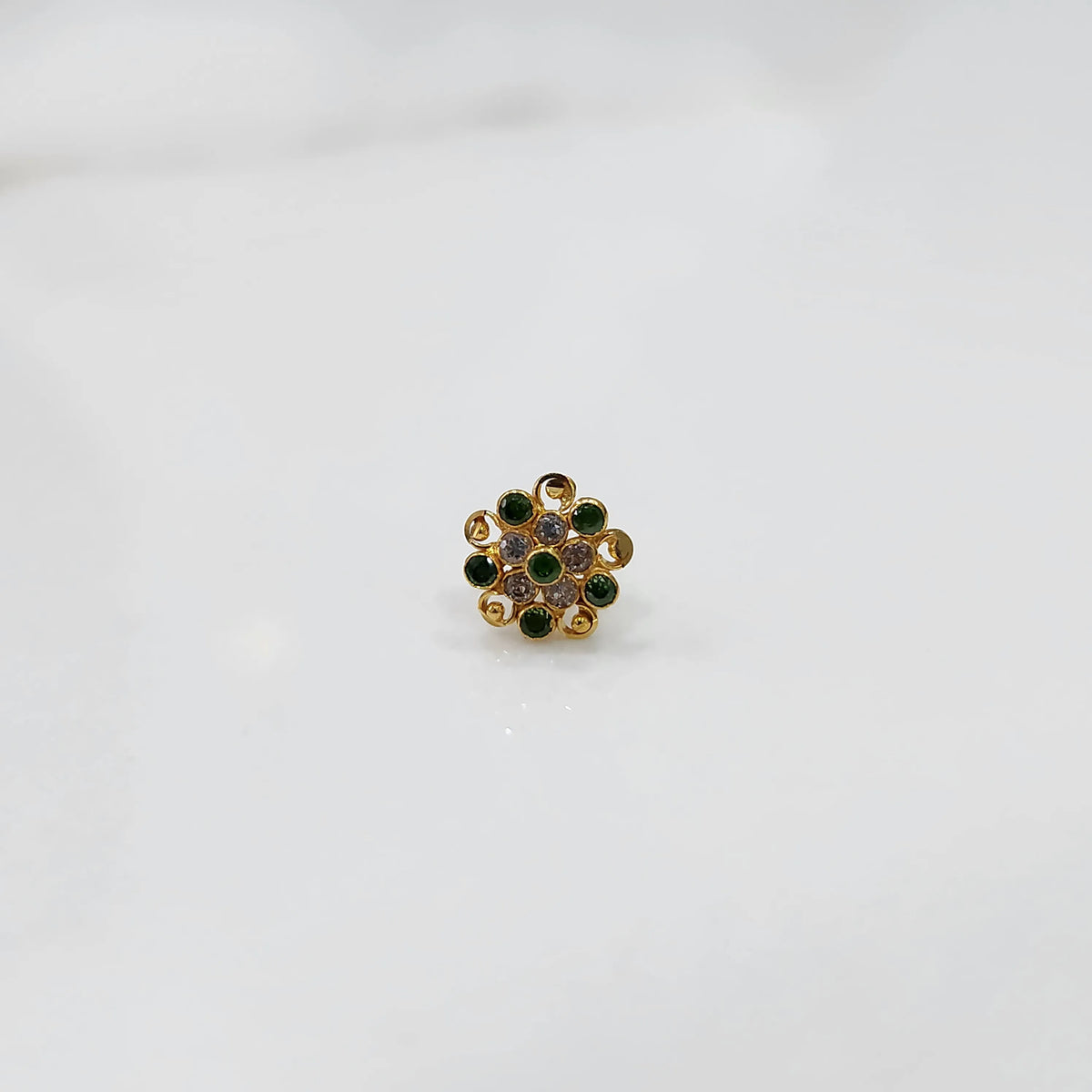 Front view of gold ring with layered green and clear gemstone petals