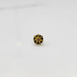Top-down view of gold ring with green gemstone petals and star center