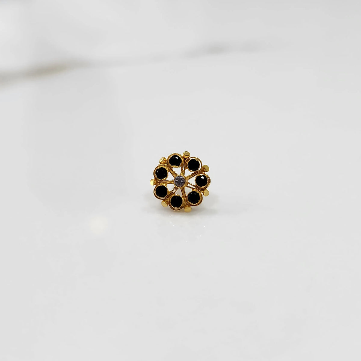 Front view of gold ring with black gemstone petals