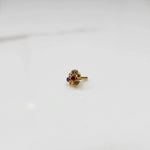 Front view of gold ring featuring red and brown gemstone cluster in round floral pattern