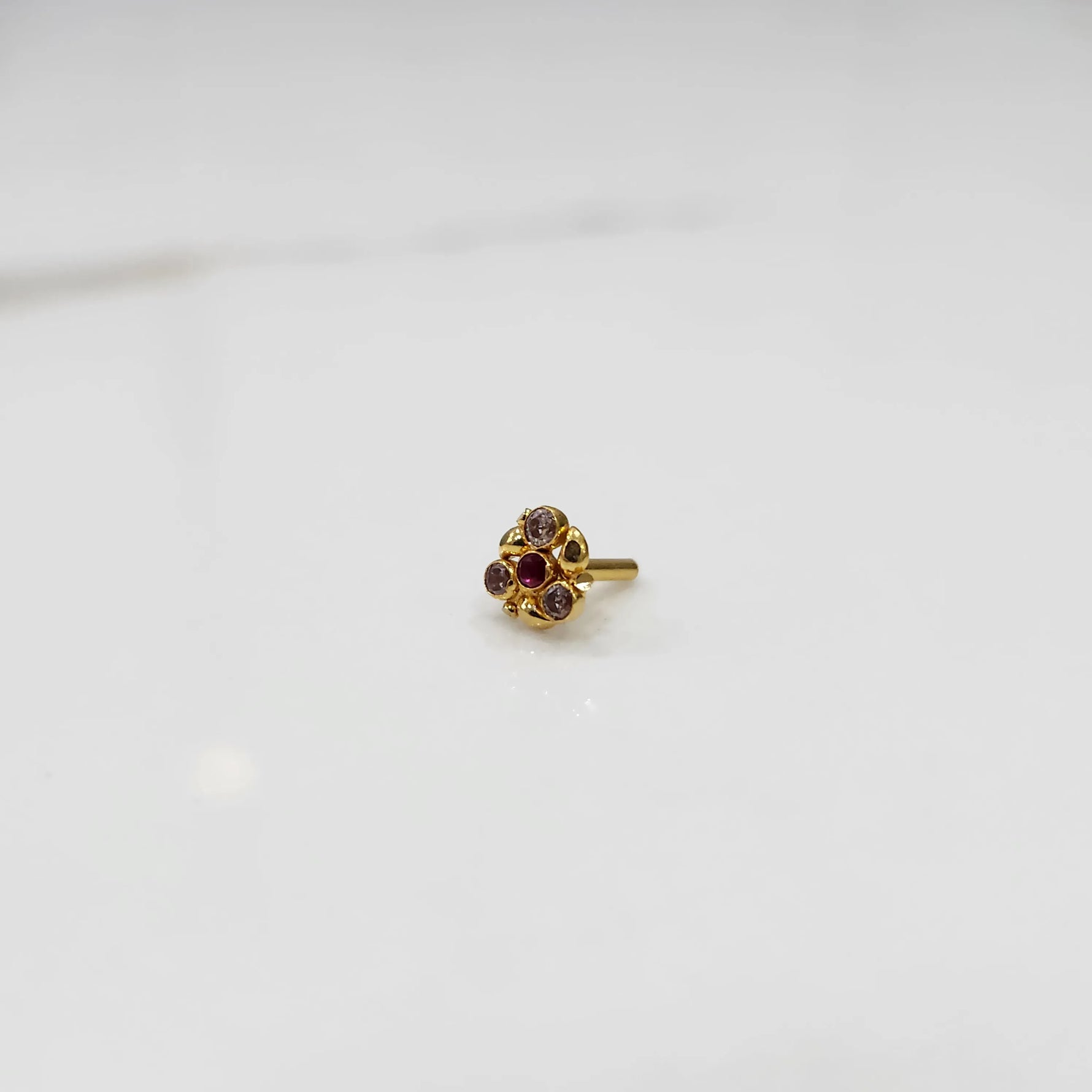 Front view of gold ring featuring red and brown gemstone cluster in round floral pattern