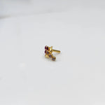 Side view of gold ring featuring red gemstone cluster with leaf accent