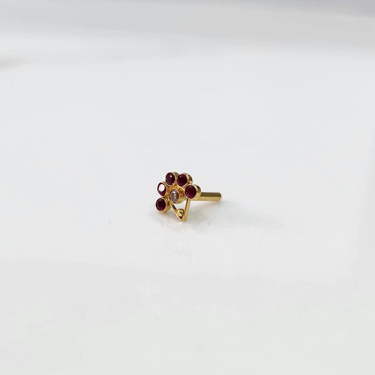 Front view of gold ring featuring red gemstone flower design