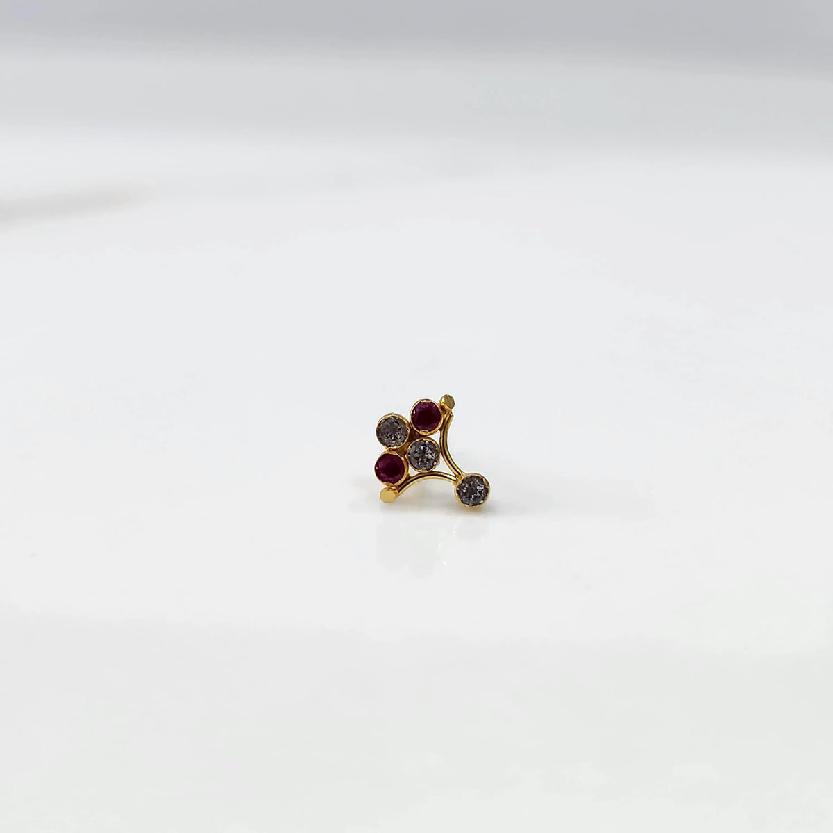 Side view of gold ring featuring red and smoky gemstone cluster on branch design