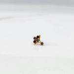 Side view of gold ring featuring red and smoky gemstone cluster on branch design