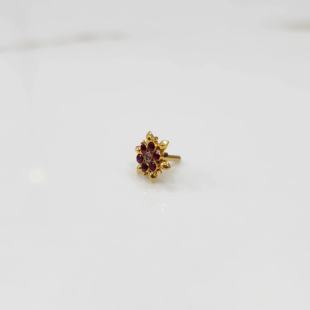 Front view of gold ring with red gemstone petals