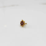 Front view of gold ring with red gemstone petals