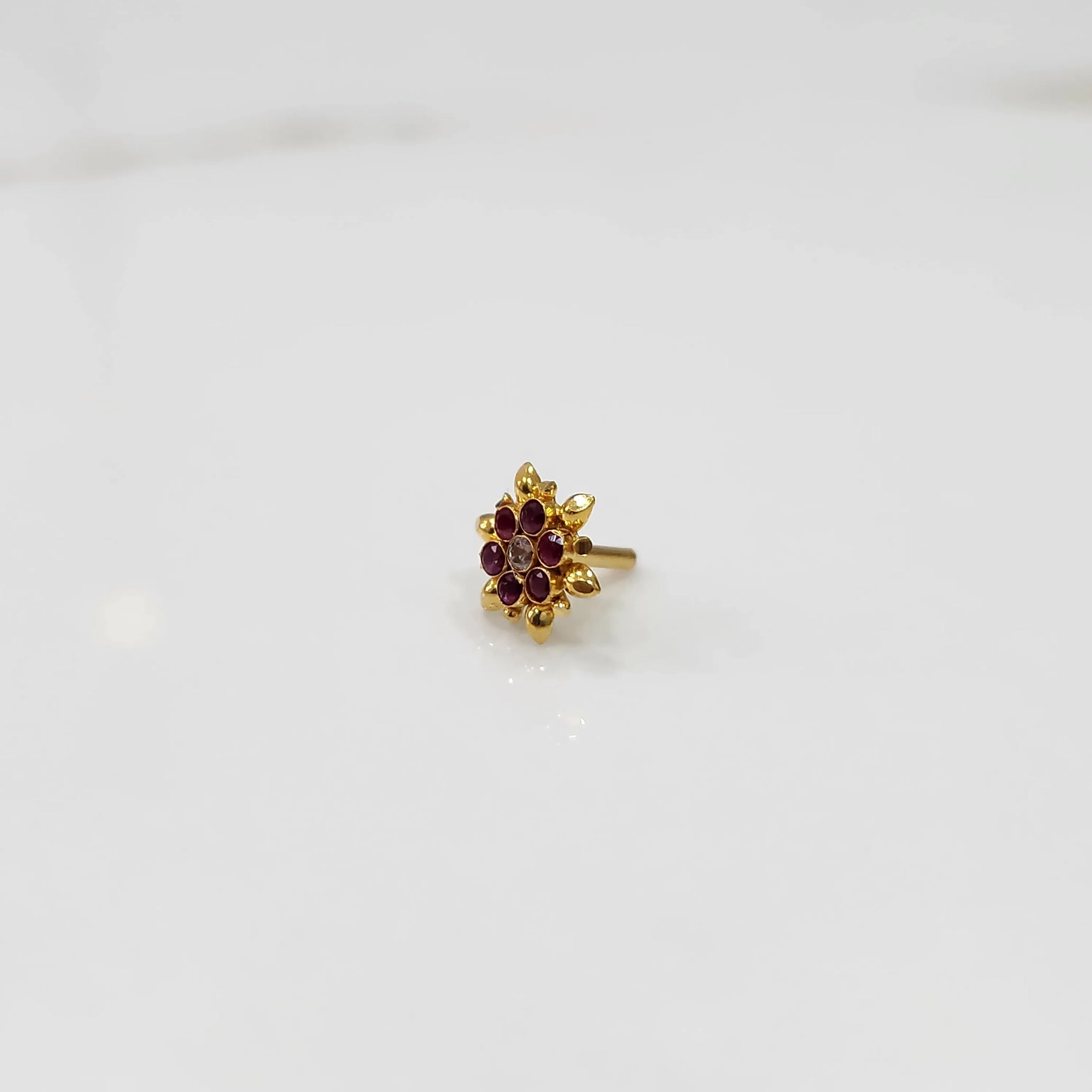 Front view of gold ring with red gemstone petals
