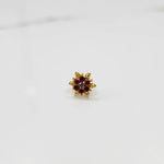 Front view of gold ring with red and white gemstone petals