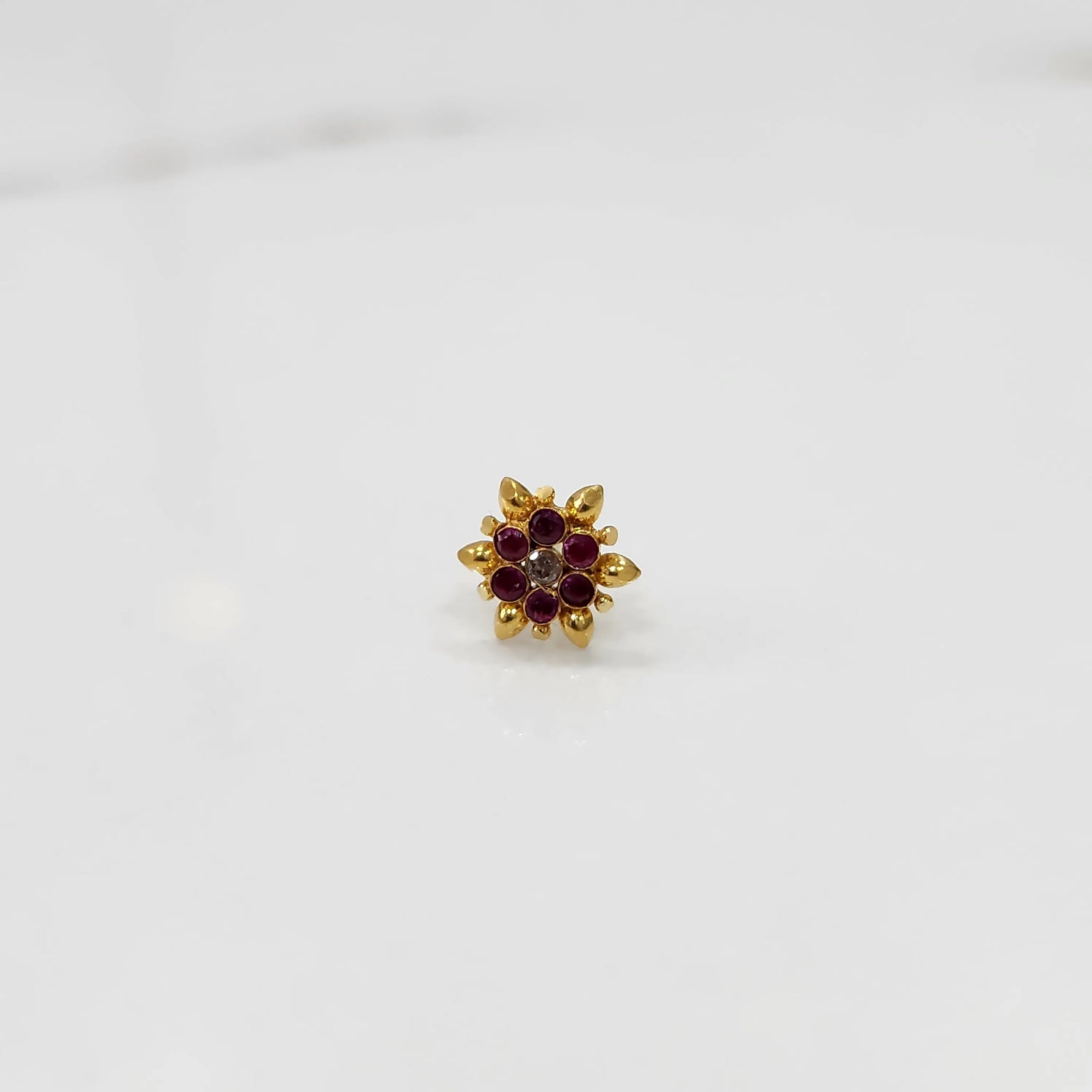 Front view of gold ring with red and white gemstone petals