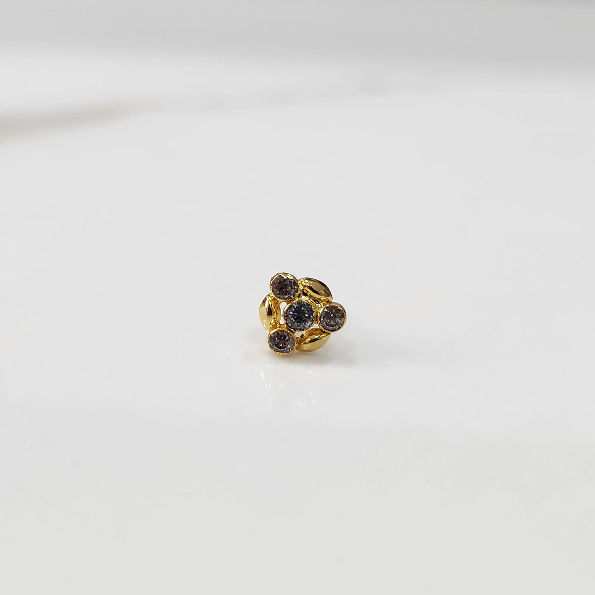 Antique-style gold ring with smoky-toned stones in leaf-petal pattern, angled view