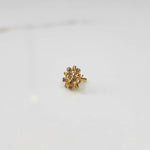 Side angle of handcrafted gold ring with flower motif and pink gemstones