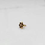 Black onyx flower cluster nose stud with gold petal design, jewelry photography
